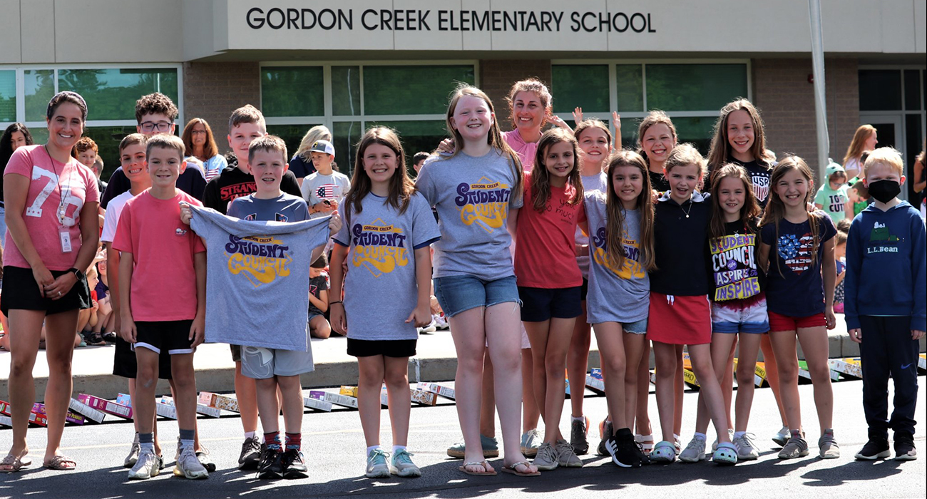 several students standing in front of the entrance of the school
